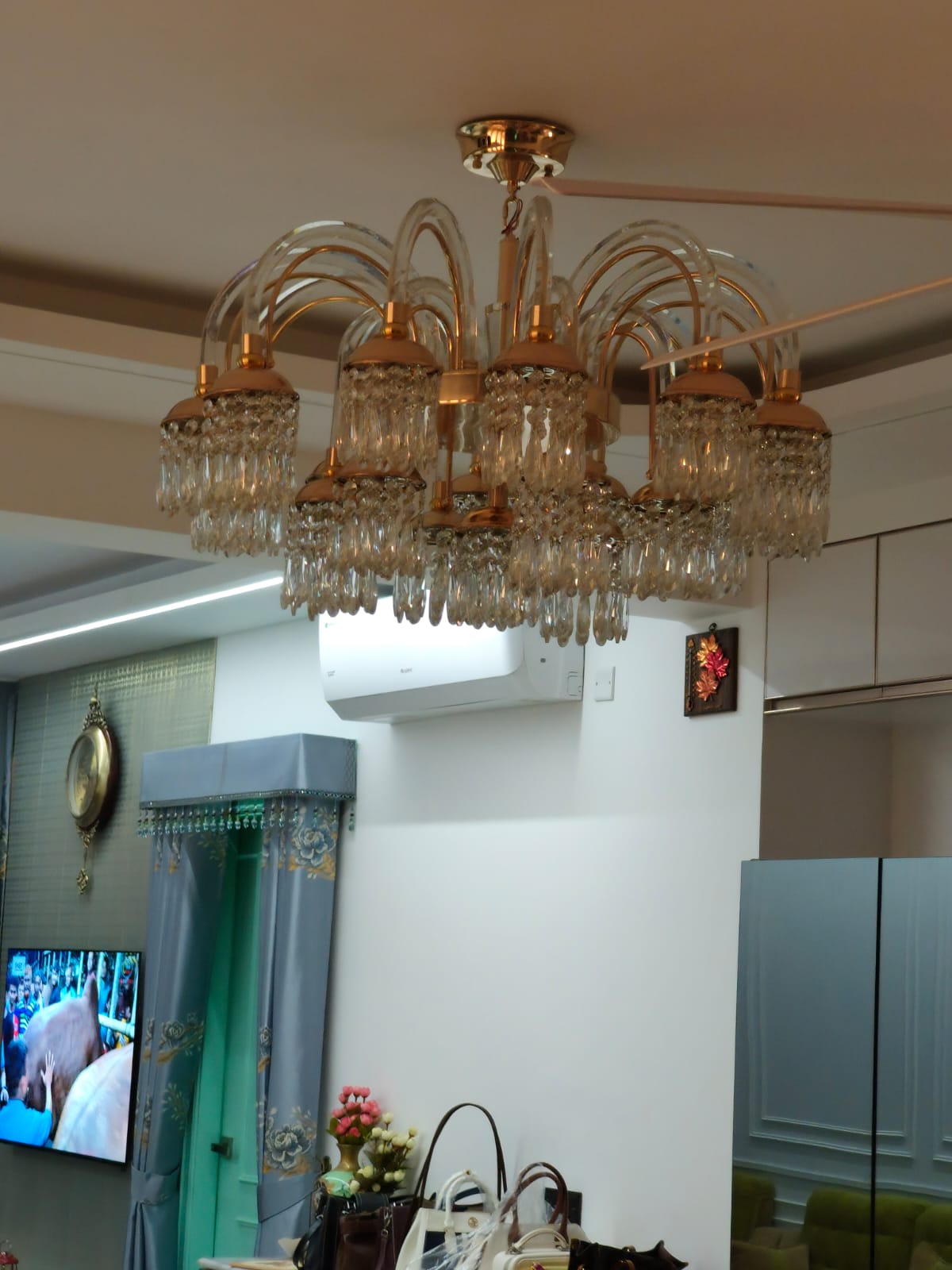 Crystal and brass chandelier installed on living room ceiling